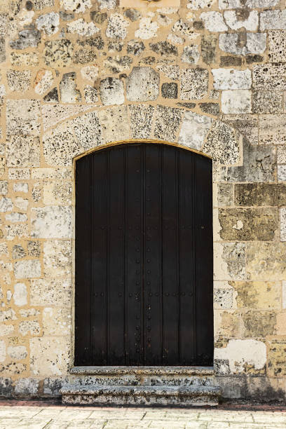 istock ancient stone wall and closed dark door 1348951822