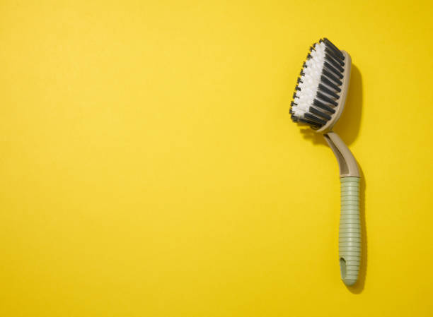 istock plastic brush with handle for cleaning the house on a yellow background, top view 1348951964