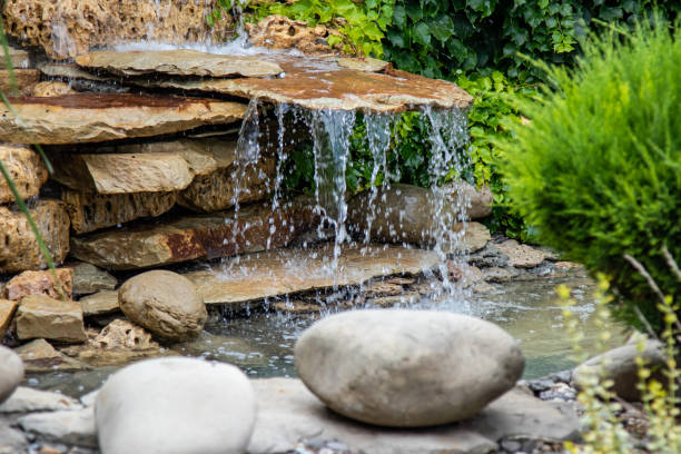 une petite cascade décorative dans le parc ou dans le jardin. aménagement paysager - fountain water stone falling water photos et images de collection