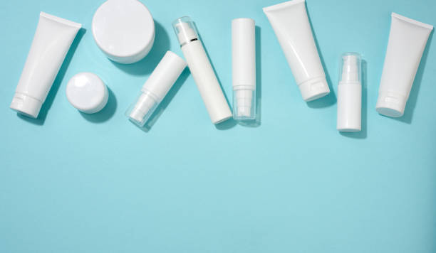 istock jar, bottle and empty white plastic tubes for cosmetics on a blue background. Packaging for cream, gel, serum, advertising and product promotion 1348952140