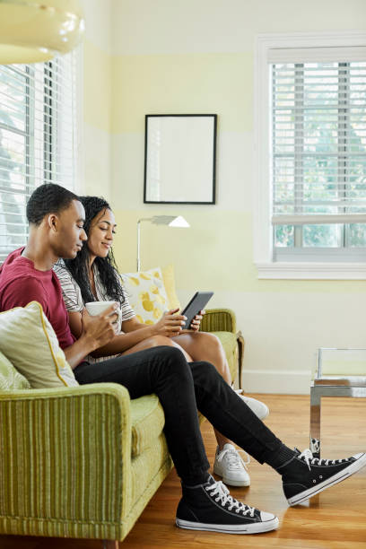 istock Couple watching digital tablet at home in lockdown 1348953849