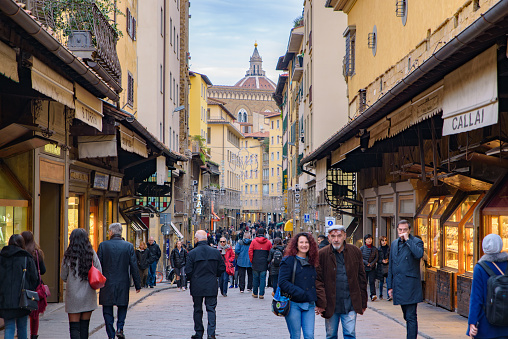 People walking on Ponte Vecchio (Old Bridge), a medieval stone bridge with shops on it, Florence, Italy