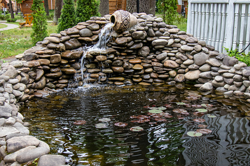 Decorative falls. pitcher of clay on beautiful stones.