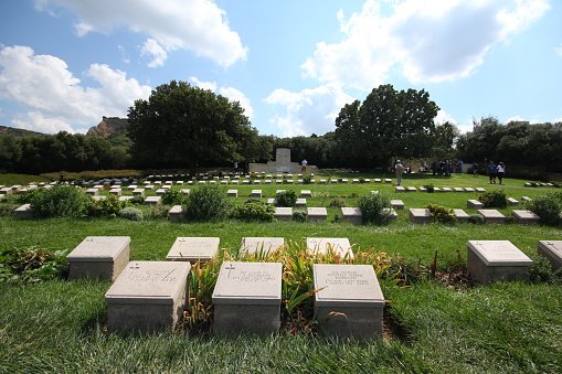 Çanakkale, Turkey-September 14, 2014: Anzac Soldier Cemetery. There are people visiting the cemetery. A field with green trees.