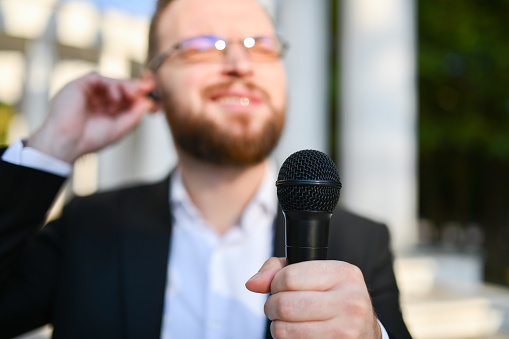 Modern Male Journalist With Earpiece Preparing For Interview