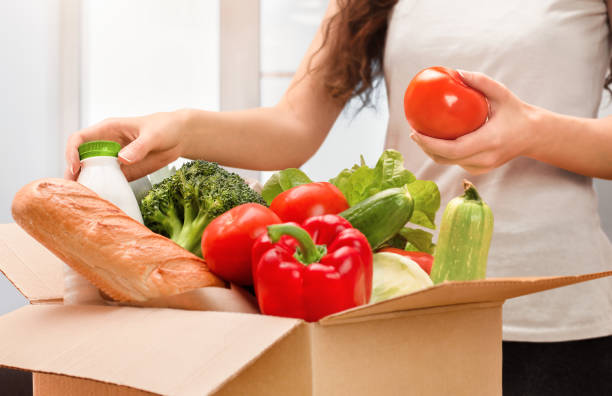 istock woman pulls groceries out of the box 1348965854