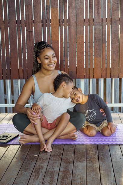 istock Young mom exercising with sons on patio 1348966656