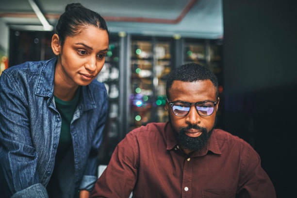 Shot of a two IT technicians working in a server room