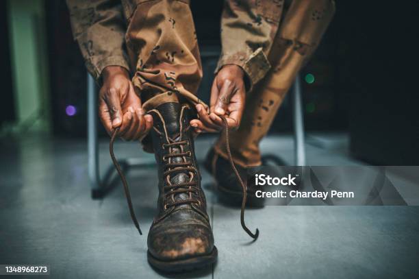 Shot Of A Soldier Tying His Boot Shoelaces In The Dorms Of A Military Academy Stock Photo - Download Image Now