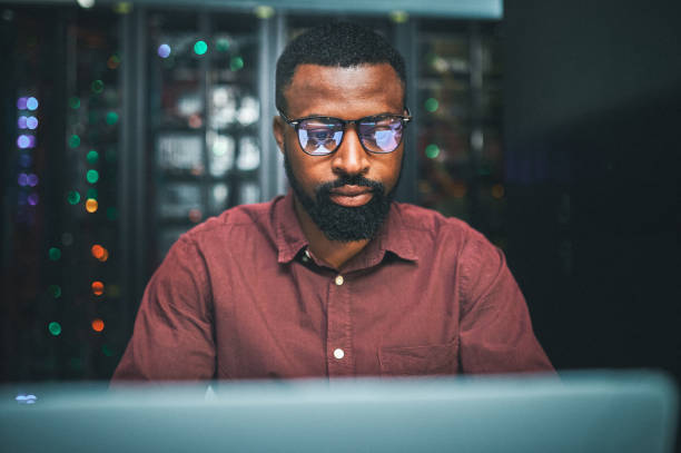 istock Shot of an male IT technician  in a server room and using a laptop 1348968293