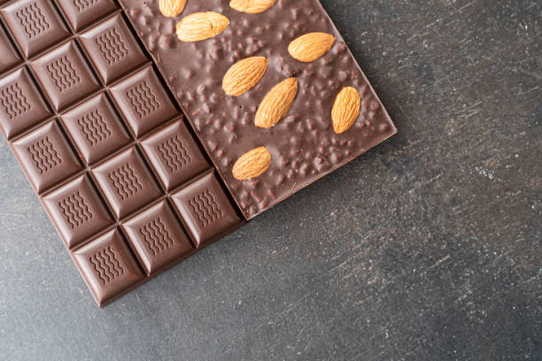 istock assortment chocolate bars with almonds, handmade sweets. Composition of bars milk and dark almond chocolate on black background, top view. Pastry craft on the table 1348974337
