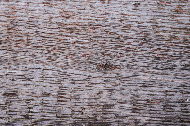 Dark aged wooden textured background with old peeling red paint.