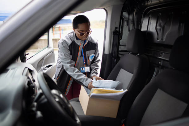 istock Delivery woman putting parcel box on the passenger sit in her delivery van 1348975521