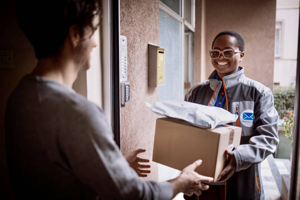 istock Homeowner receives parcel while standing in the open doorway. 1348975556