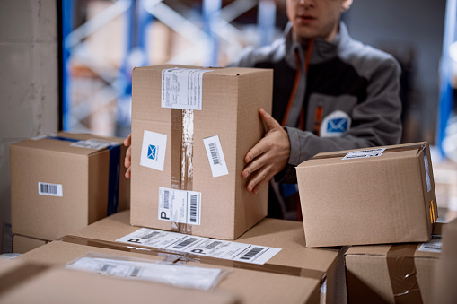 Delivery person rushing to load packages in a delivery van.