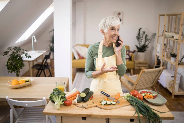 istock Woman talking on mobile and preparing food 1348976817