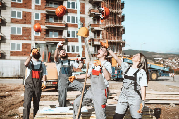 istock Happy Construction Team Throwing Helmets In Air After Completing Tough Work 1348977798