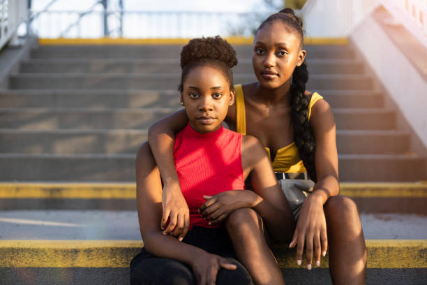 Portrait of two young female sitting on the stairs stock photo