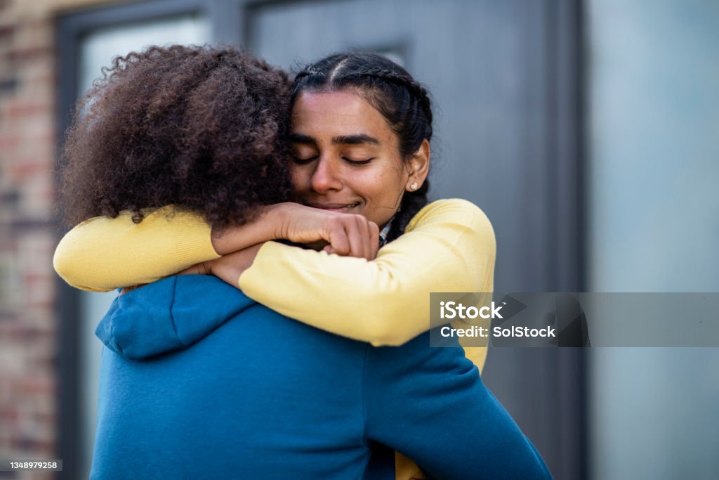 I Love You So Much Medium shot of a young couple standing outside of the lodge they're staying on during a staycation in the Northeast of England together. They are embracing and laughing with each other. The man is picking up his partner. Embracing Stock Photo