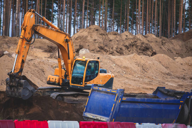 istock Yellow heavy excavator and bulldozer excavating sand and working during road works, unloading sand during construction of the new road 1348979412