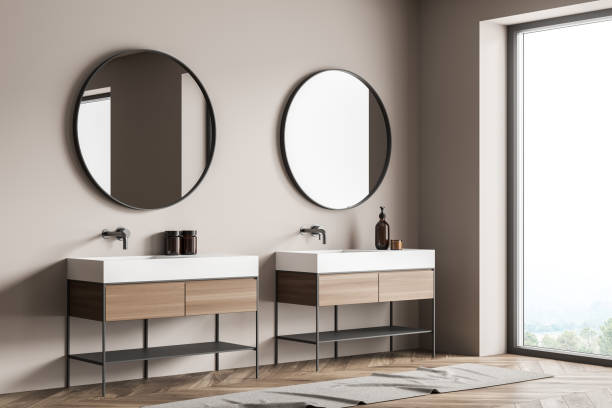 istock Corner view of bathroom wall with two round mirrors over two vanities 1348983256