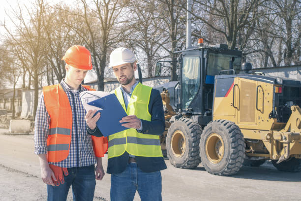 istock Surveyor and equipment at construction site. Excavator and Construction Equipnent on background. 1348983785