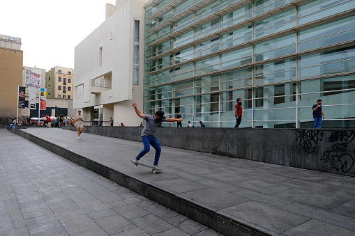 A skateboarder rides outside of Barcelona Museum of Contemporary Art in Spain on October 3, 2021.