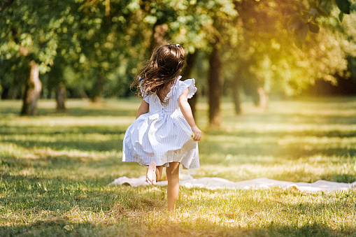 Little girl running in the park barefoot