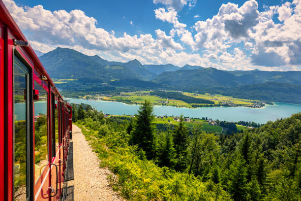 tren de montaña schafbergbahn, montaña schafberg, región de salzkammergut, estado de salzburgo, austria. viaje a la cima de los alpes a través de exuberantes campos y bosques verdes. vista del lago wolfgangsee. - railroad track train journey rural scene fotografías e imágenes de stock