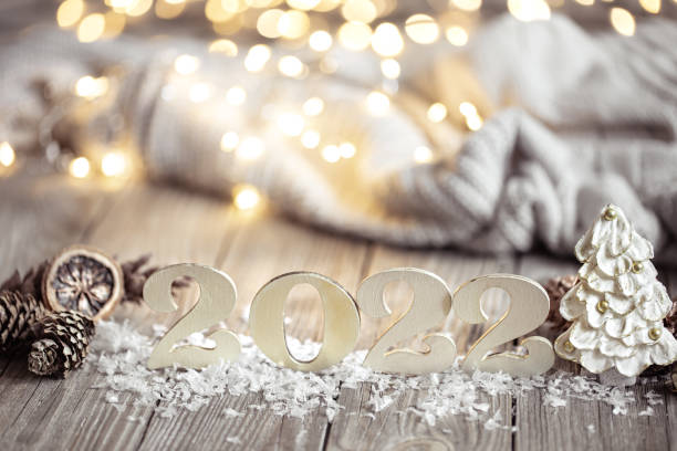 istock Cozy Christmas composition with number 2022 and decor details on blurred background with bokeh. 1348992708