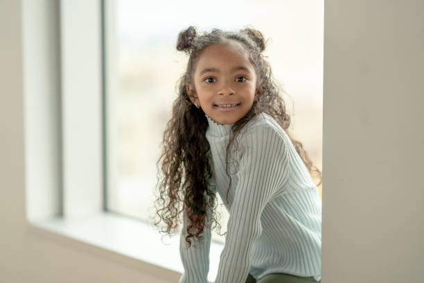 istock Young Girl on a Window Ledge Portrait 1348999239