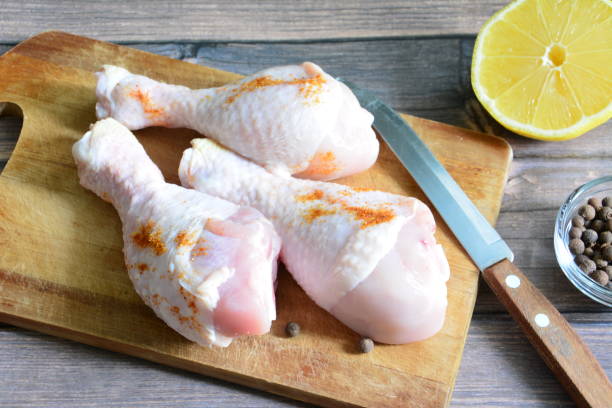 raw chicken legs on cutting board with kitchen knife, lemon and allspice raw chicken legs on cutting board with kitchen knife, lemon and allspice drumstick stock pictures, royalty-free photos & images