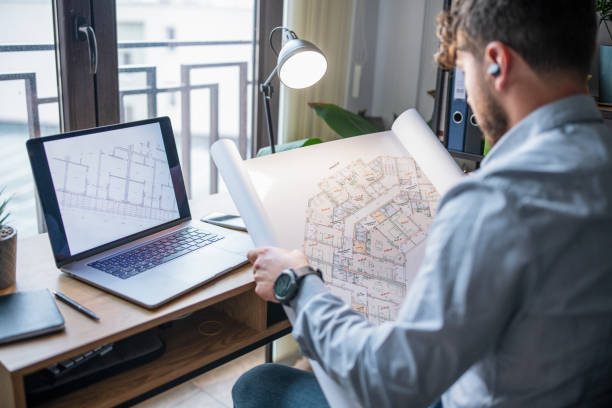 istock Male Architect Looking At Blueprint At Home 1349004725