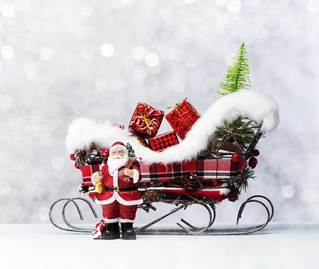 Christmas or New Year background. Santa Claus and sleigh with Christmas gifts. Festive decorations and presents for winter holidays