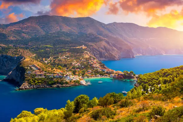 Photo of Assos village in Kefalonia, Greece. Turquoise colored bay in Mediterranean sea with beautiful colorful houses in Assos village in Kefalonia, Greece, Ionian island, Cephalonia, Assos village.