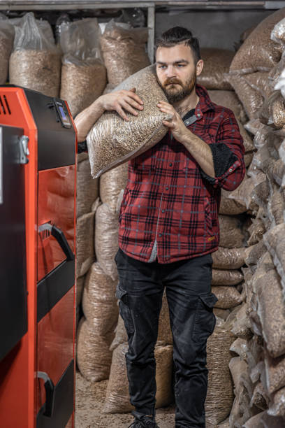 istock The man loads the pellets in the solid fuel boiler, working with biofuels. 1349005760