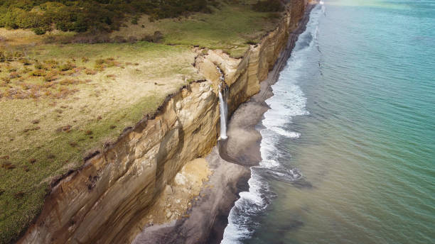 Waterfall on Golovinsky Cliff on Kunashir Island, Kuril Islands, Russia. Aerial photography Waterfall on Golovinsky Cliff on Kunashir Island, Kuril Islands, Russia. Aerial photography. kunashir island stock pictures, royalty-free photos & images