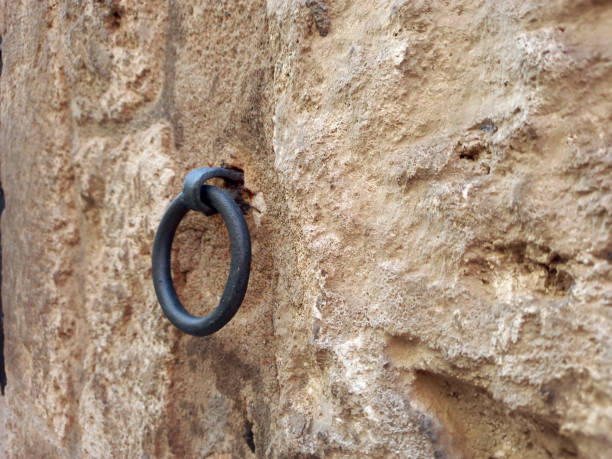 istock Side view of Old metal Iron Ring On Stone Wall. Stone wall with wrought iron ring. Architecture and construction. 1349008093