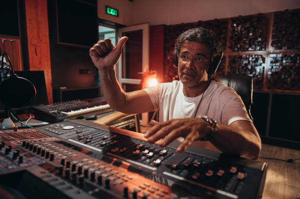 istock Senior hispanic music producer working on a mixing soundboard while in his studio 1349009697