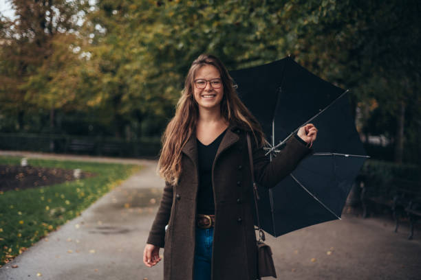 istock Beautiful young woman holding an umbrella 1349010597