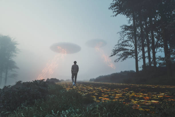 istock Man walking towards UFOs on the rural road 1349012102