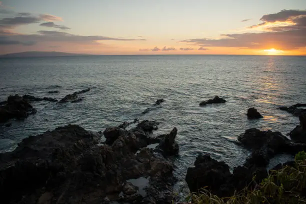 The sun sets off the coast of Maui, Hawaii over Charley Young Beach outside Kehei.