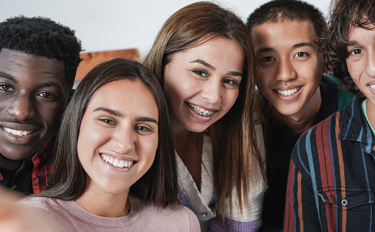 Group of multiracial young friends taking a selfie at home - Diverse young people and generation z lifestyle concept