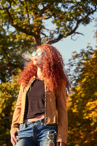 Red haired young beautiful woman with sunglasses enjoying summer sun