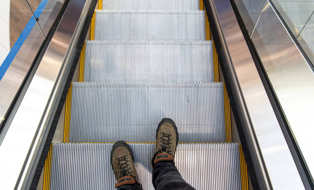 istock Male feet on the escalator, top view. 1349013693