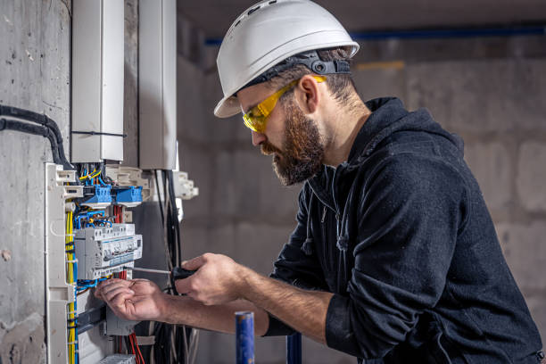 istock A male electrician works in a switchboard with an electrical connecting cable. 1349015004