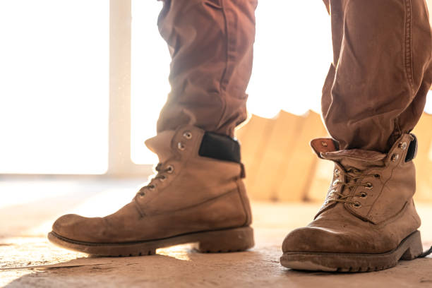 istock Close-up of work shoes of a builder at a construction site, copy space. 1349015017