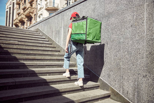 istock Female courier delivering fast food to clients downtown 1349015101