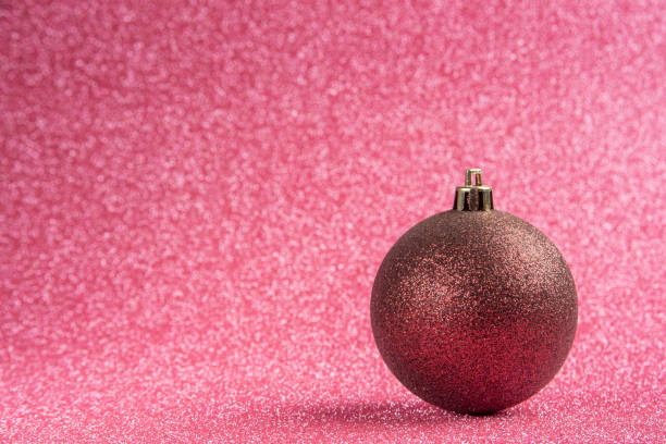 istock Plastic and glitter Christmas ornaments on pink surface with glitter. selective focus. 1349016667