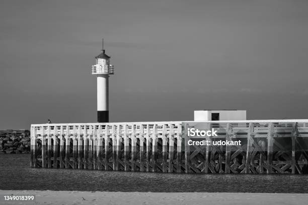 Alone By The Lighthouse Stock Photo - Download Image Now - Black And White, People, Atmospheric Mood